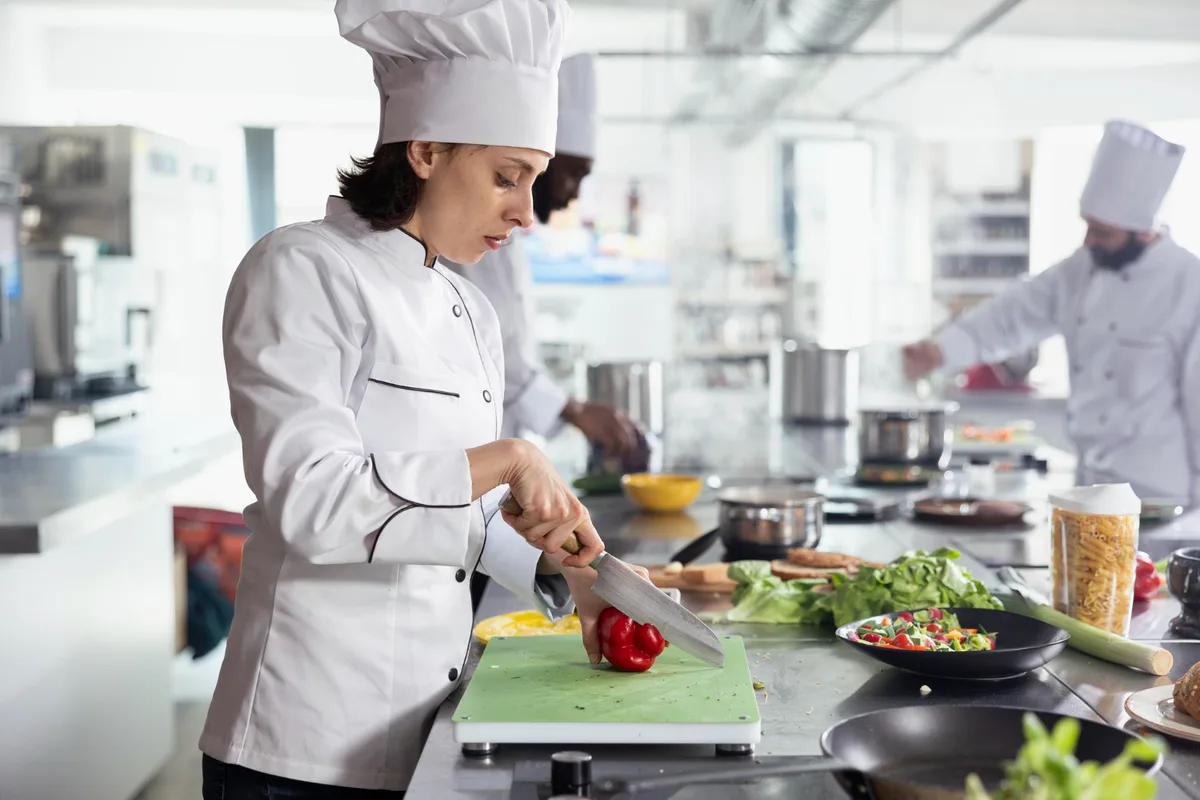 Horecamedewerker controleert de temperatuur van een gerecht tijdens de bereiding